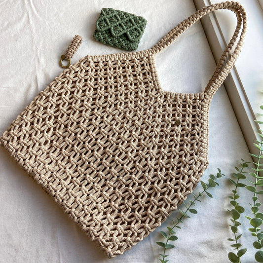 Hand knotted macrame beach bag with soft open weave and wide shoulder straps, handmade by Flora Street Atelier, crafted in Canada with recycled cotton
