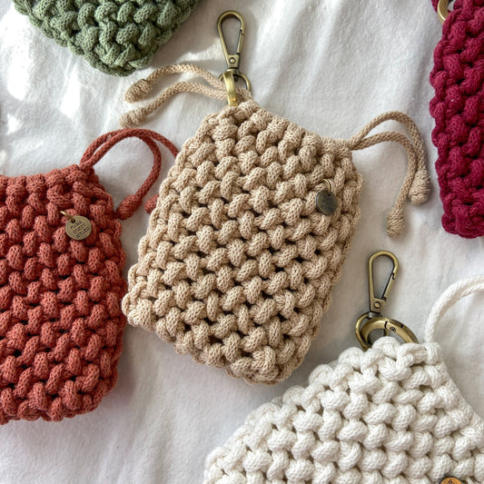 Collection of hand knotted mini pouches in various colors on a white background